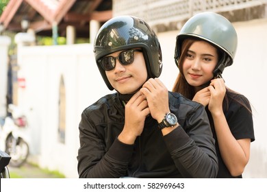 Young Adult Asian Couple, Male And Female Biker Or Motorcyclist Wearing Safe Helmet Before Travel On Motorcycle As Accident Prevention Or Safety Riding Concept.