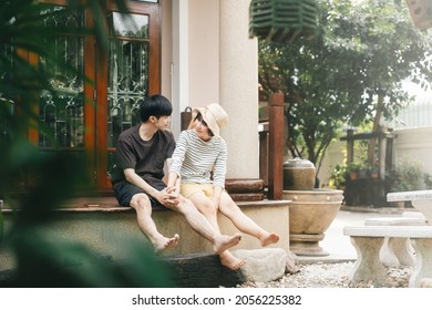 Young adult asian lover couple together living at home concept. Sitting at garden terrace leisure on day. House with nature green zone for wellness lifestyle.