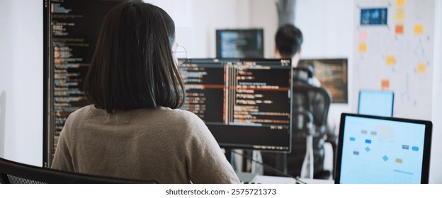 Young adult Asian male, female software developer coding program on desktop computer. Man, woman work from home, remote working, freelance programmer job, smart digital nomad lifestyle concept