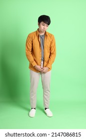 The Young Adult Asian Man With Smart Casual Clothes Standing On The Light Green Background.