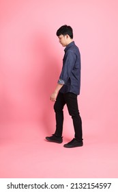 The Young Adult Asian Man Standing On The Pink Background.