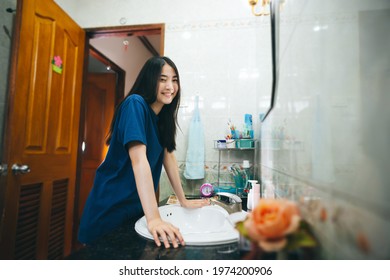 Young Adult Asian Woman Practice Self And Checking By Mirror In Bathroom At Home. Mental Health Maintain Lifestyle After Wake Up Concept. Eye Looking Camera.