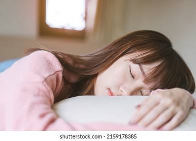 Young Adult Asian Woman Sleep In Bedroom On Morning. Stay At Home Rest On Bed And Pillow. Wear Pink Sweater And Good Face. People Health Well Good Relax Lifestyle In Cozy Place.