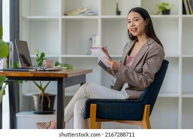 Young Adult Asian Women Work At Home Or Modern Office, Using A Notebook Laptop Computer. Work From Home Life, Information Technology, Domestic Lifestyle, Or Self-isolation Working Concept