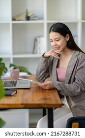 Young Adult Asian Women Work At Home Or Modern Office, Using A Notebook Laptop Computer. Work From Home Life, Information Technology, Domestic Lifestyle, Or Self-isolation Working Concept