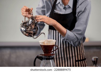 Young adult baristas follow recipes to create artisan and specialty beverages. Making drip coffee with a unique way. Small business owners practice the sense of taste and scent at slow bar coffee.