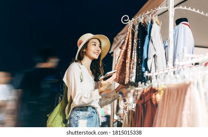 Young Adult Beautiful Woman Happy Relax Outdoor In Urban Lifestyle Concept. Her Shopping Cheap Price At Street Night Market Tourist Destination In Bangkok, Thailand