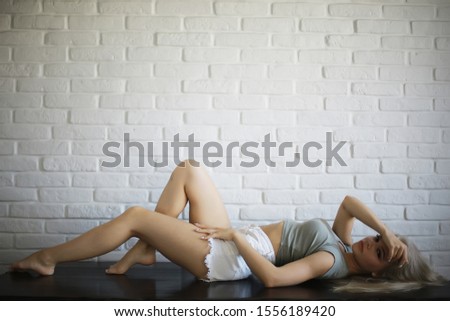 young adult blonde long hair at home, stylish model posing in the studio