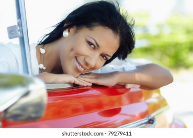 Young Adult Brunette Woman Leaning On Convertible Red Car And Looking At Camera. Horizontal Shape, Side View