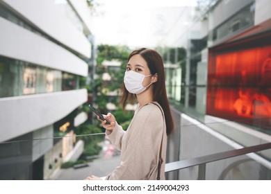 Young Adult Business Asian Woman Using Mobile Phone For Shopping Online Via Digital Wallet. Lifestyle With Technology. Single Businesswoman Wear Face Mask.