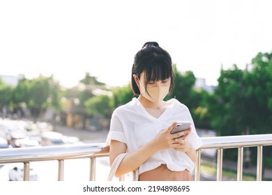 Young Adult Business Asian Woman Using Mobile Phone For Shopping Online Via Digital Wallet. Lifestyle With Technology. Single Businesswoman Wear Face Mask.