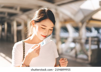 Young adult business southeast asian beautiful woman wearing or remove face mask. City break people lifestyle with public health on day concept. - Shutterstock ID 2194899955