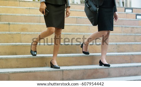 Young adult business women walking down the stairs