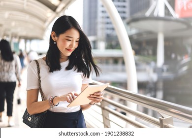 Young adult business working asian woman using digital tablet for online application stock market.  Lifestyle with modern technology. Background with copy space on day.