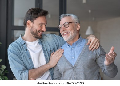 Young Adult Caucasian Son Listening And Supporting His Old Elderly Senior Father At Home Indoors.Happy Father`s Day! Care And Love Concept. I Love You, Dad!