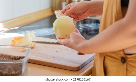 Young Adult Cooking Vegan Food With Onion