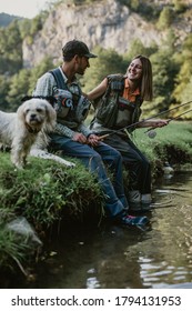 Young Adult Couple Is Fishing Together On Fast Mountain River. Active People And Sport Fly Fishing Concept.