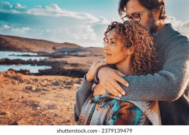 Young adult couple in love in outdoor leisure activity admiring travel destination. Contemplation. People traveler and adventure lifestyle. Man hug woman from behind. Looking away, togetherness two - Powered by Shutterstock