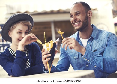 Young Adult Couple Sharing French Fries 
