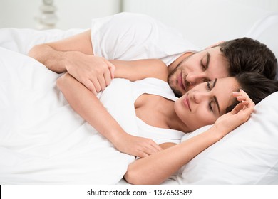 Young adult couple sleeping on the bed in bedroom