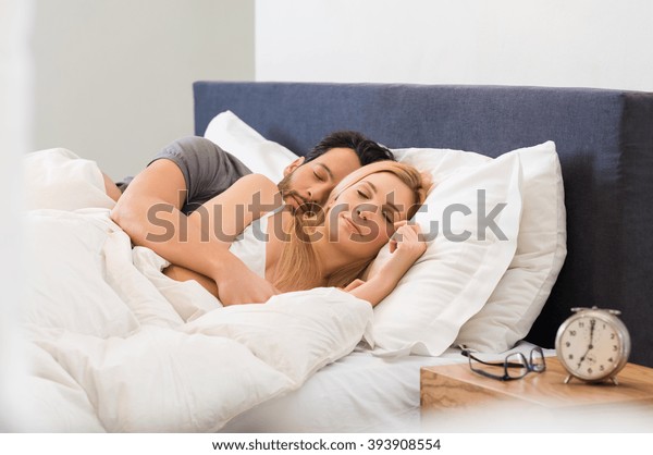 ベッドの上で寝静かに眠る若い大人の夫婦 寝ながら女を抱きしめる若い男 家でベッドに横になって眠る愛し合いの夫婦 の写真素材 今すぐ編集