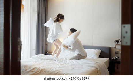 Young adult couple two asia people relax joy fun smile laugh spend good time play pillow fight war on bed at cozy home asian lover just married man woman in family day life begin happy sweet moment. - Powered by Shutterstock