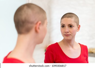 Young Adult Female Cancer Patient Looking In The Mirror.