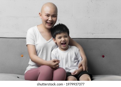 Young Adult Female Cancer Patient Spending Time With Little Son On Gray Background. Cancer And Family Support Concept.