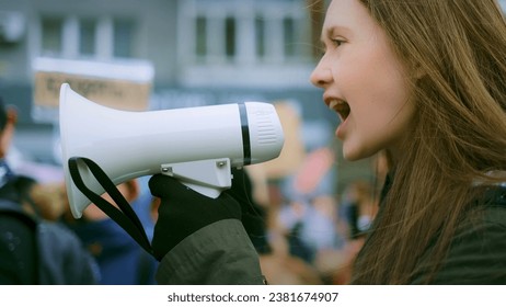 Young adult female feminist demonstration. Gender rights feminism fight. Women march movement power sign equality. Gender woman strike empowerment action. Social message. Crowd people city street day. - Powered by Shutterstock