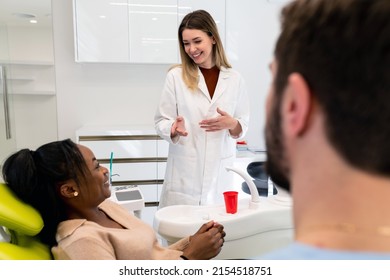 Young Adult Female Patient Sitting On A Dental Chair And Having A Conversation With Her Dentist. Preparing Patient For A Treatment. Focus On A Female Dentist.