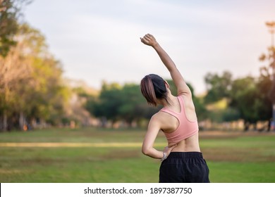 Young Adult Female In Pink Sportswear Stretching Muscle In The Park Outdoor, Sport Woman Warm Up Ready For Running And Jogging In Morning. Wellness, Fitness, Exercise And Work Life Balance Concepts