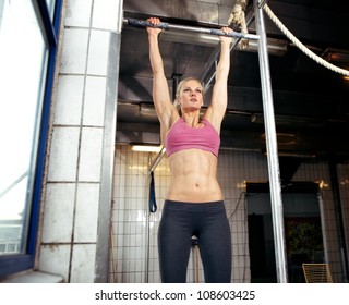 Young adult fitness woman preparing to do pull ups in pull up bar. - Powered by Shutterstock