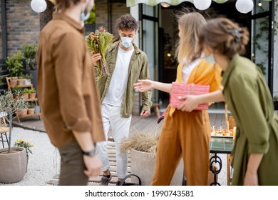 Young Adult Friends Gathering For Birthday Party At The Backyard Of Country House. Wearing Face Masks And Greet With Social Distance, New Normal During Pandemic