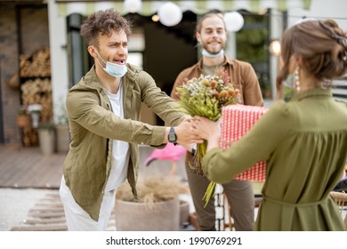 Young Adult Friends Gathering For Birthday Party At The Backyard Of Country House. Wearing Face Masks And Greet With Social Distance, New Normal During Pandemic