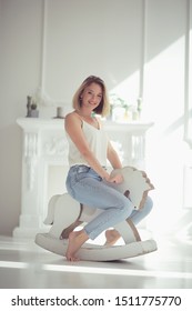 Young Adult Girl On A Rocking Horse / Unusual Photo Of A Girl In The Studio Funny Laugh