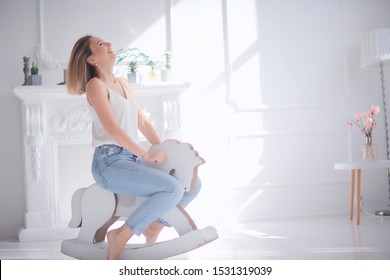 Young Adult Girl On A Rocking Horse / Unusual Photo Of A Girl In The Studio Funny Laugh