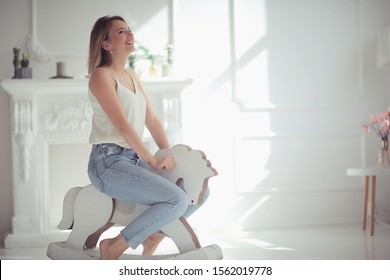 Young Adult Girl On A Rocking Horse / Unusual Photo Of A Girl In The Studio Funny Laugh