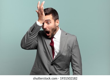 young adult handsome businessman raising palm to forehead thinking oops, after making a stupid mistake or remembering, feeling dumb