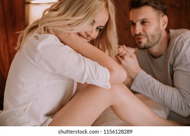 Young adult heterosexual couple on bed in bedroom at home - Shutterstock ID 1156128289