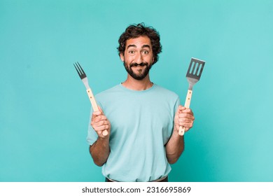 young adult hispanic crazy man with barbecue tools