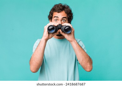 young adult hispanic crazy man with binoculars. searching concept - Powered by Shutterstock