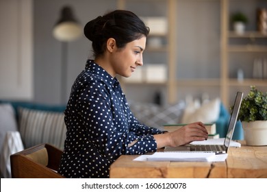 Young Adult Indian Woman Student Using Laptop Computer Study In Internet, Focused Girl Typing Looking At Notebook Working Online E Learning With Education Software Technology Sit At Home Office Table