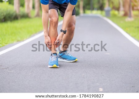 Young adult male with his muscle pain during running. runner man having leg ache due to Shin Splints. Sports injuries and medical concept