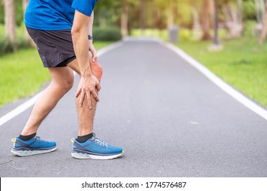 Young Adult Male With Muscle Pain During Running. Runner Have Knee Ache Due To Runners Knee Or Patellofemoral Pain Syndrome, Osteoarthritis And Patellar Tendinitis. Sports Injuries And Medical Concept