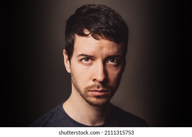 Young adult man with brown hair and beard with sceptic anger facial expression looking at camera - Powered by Shutterstock