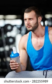 Young Adult Man Drinking Protein Shake In Modern Gym