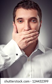 Young Adult Man Holding Hand Over His Mouth Over Grey Background