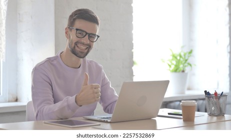 Young Adult Man Showing Thumbs Up While using Laptop - Shutterstock ID 2257532869