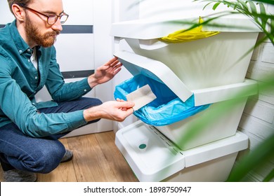 A Young Adult Man Throwing A Piece Of Paper Into A Recycling Bin, Container For Paper. Waste Segregation At Home. 