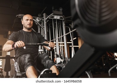 young adult man using rowing machine in the gym for training - Powered by Shutterstock